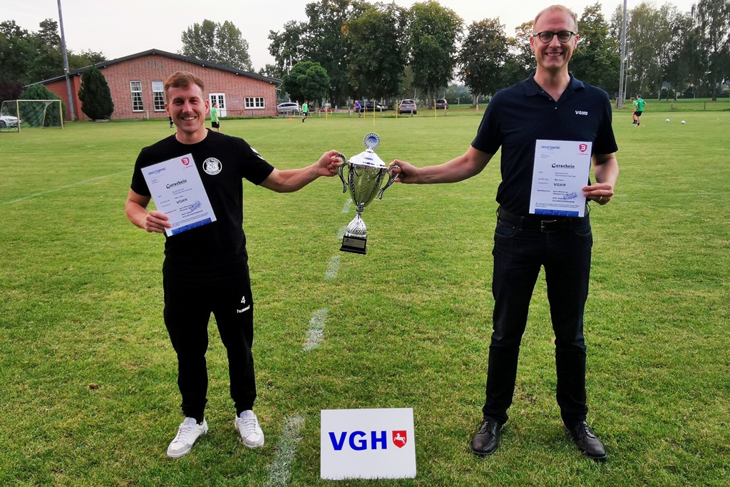 Kapitän Hauke Zechel erhält den Pokal von Jan Nerlich (Vertriebsleiter VGH-Regionaldirektion Lüneburg)